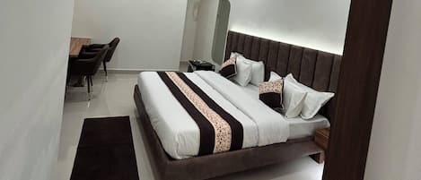 Un dormitorio moderno con cama, mesita de noche y ventilador de techo.