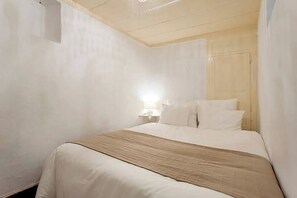 Ein Hotelzimmer mit Bett, Nachttisch und Lampe.