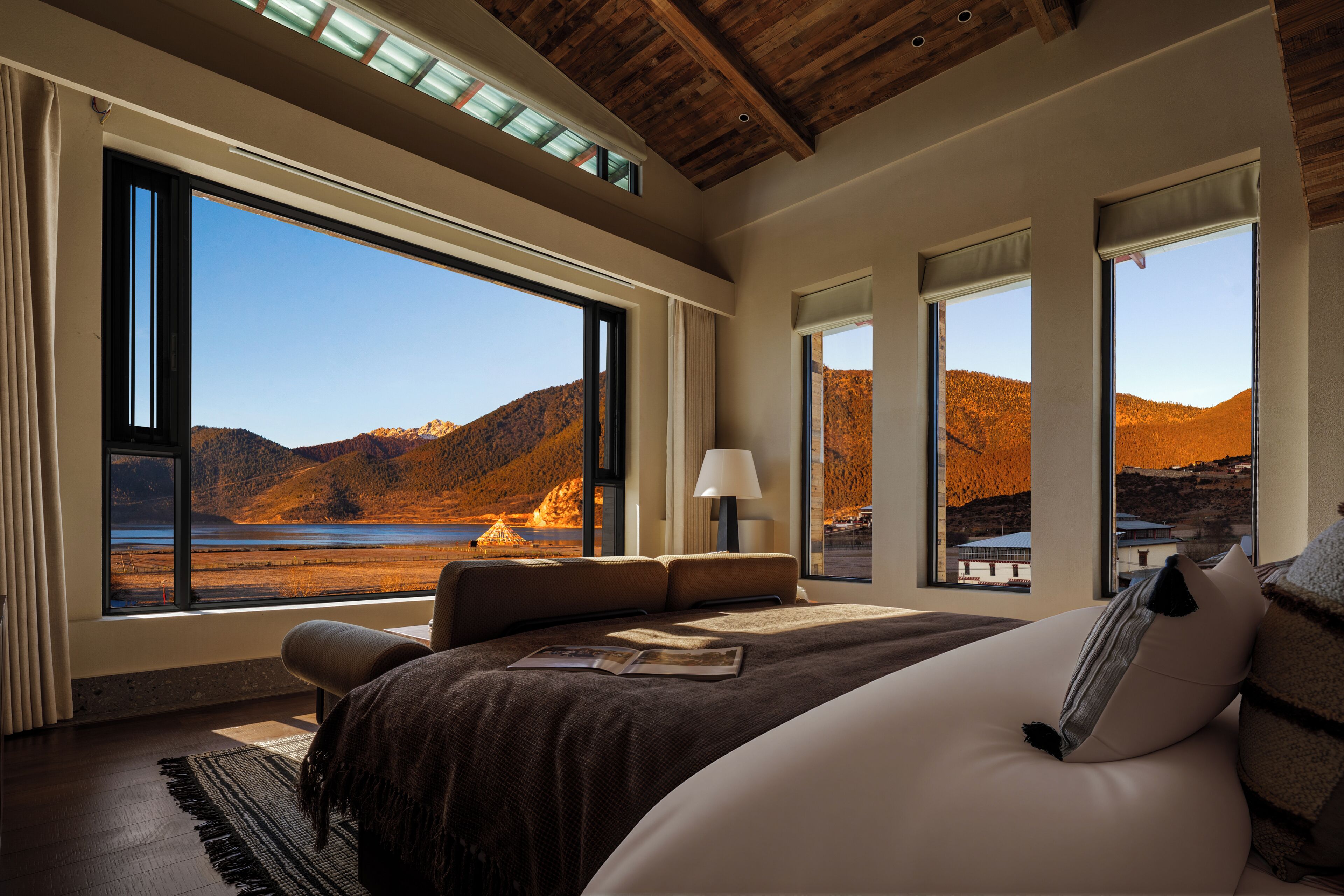 Un dormitorio con un ventanal grande que da a un paisaje montañoso.