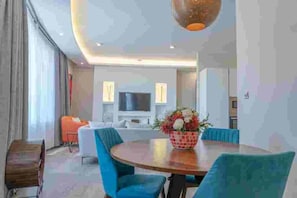 A modern dining area with a round table, blue upholstered chairs, and a decorative centerpiece. - Luxury and spacious 1BR Apartment at the Curve by the Park Nairobi Mombasa road. (Nairobi)