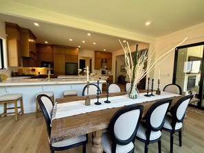 A modern kitchen with wooden cabinets, a central island, and a dining area with a wooden table and chairs. - 2.8 Miles from Augusta National, this home is the perfect base for the Masters! (Augusta)