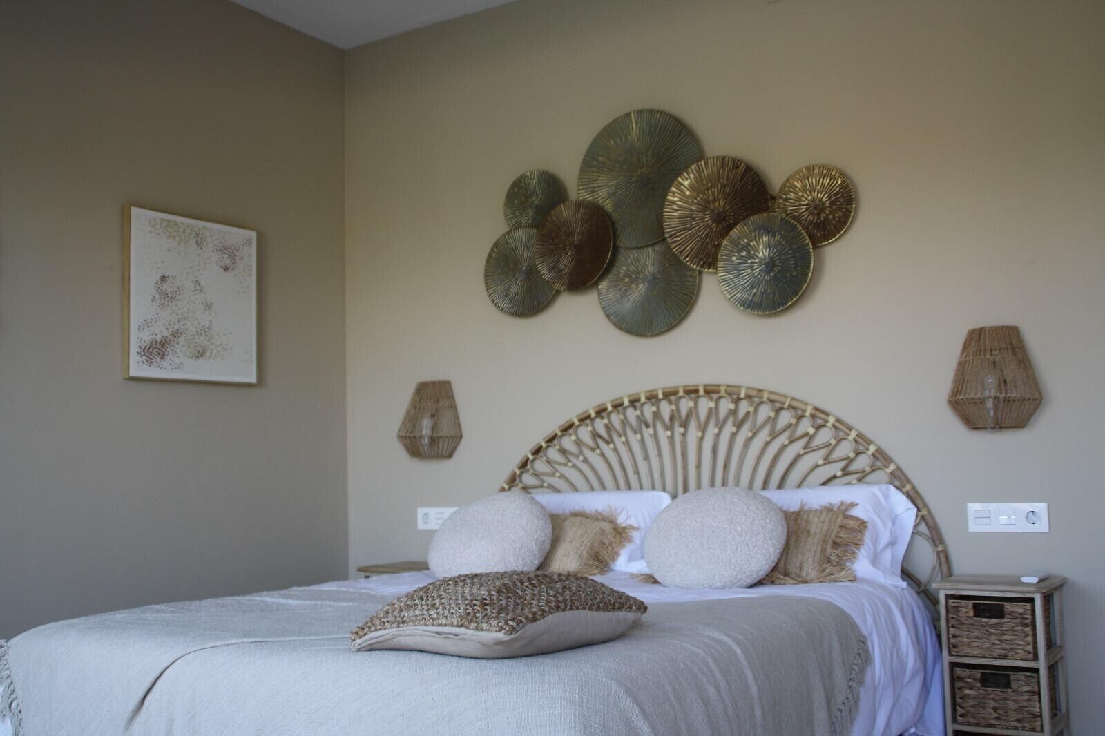 Un dormitorio con cama, decoración mural y mesita de noche.