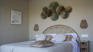 A bedroom with a bed, decorative wall art, and a bedside table.