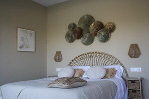 A bedroom with a bed, decorative wall art, and a bedside table.