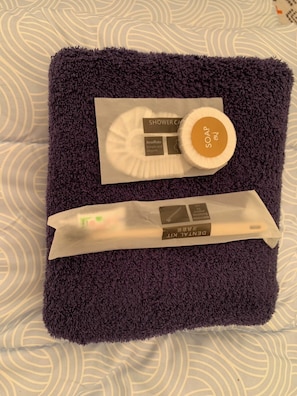 A purple towel with a shower caddy and a bar of soap. - Riverside Glamping Resort Kanchanaburi (Kanchanaburi)