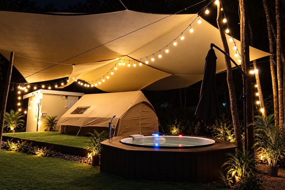 A tented outdoor area with a hot tub and string lights.