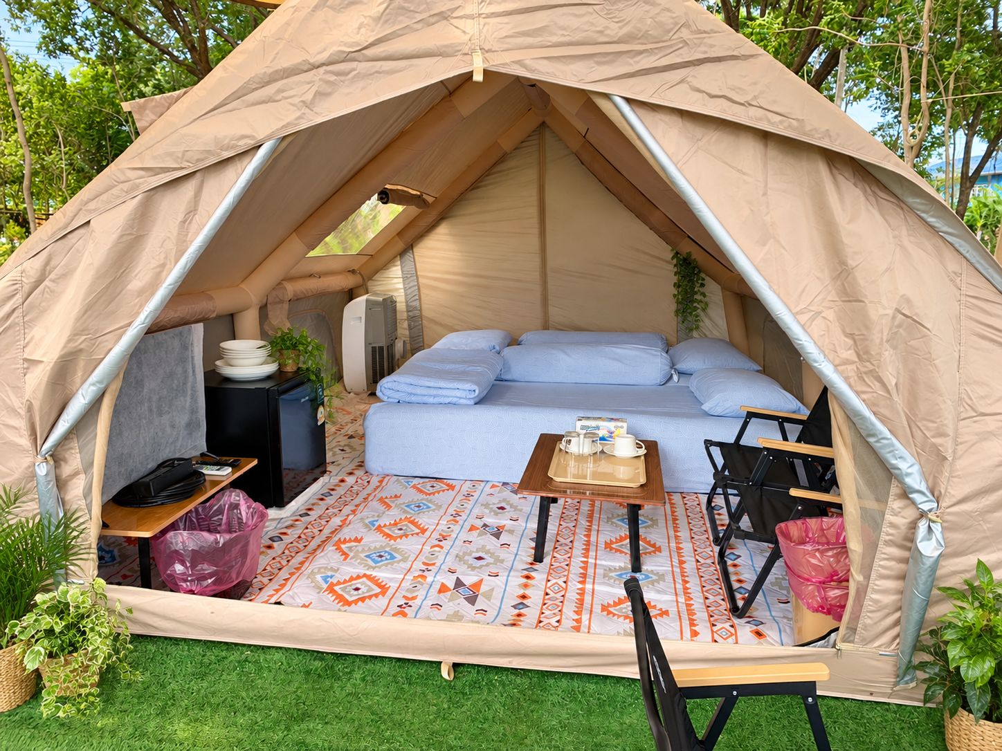 Ein Zelt mit einem Bett, einem Tisch mit Tablett und einem tragbaren Heizgerät.