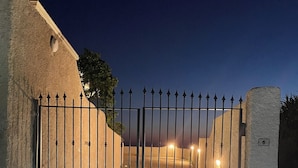 A gated entrance with a metal gate, a concrete wall, and a number sign indicating the gate's position.