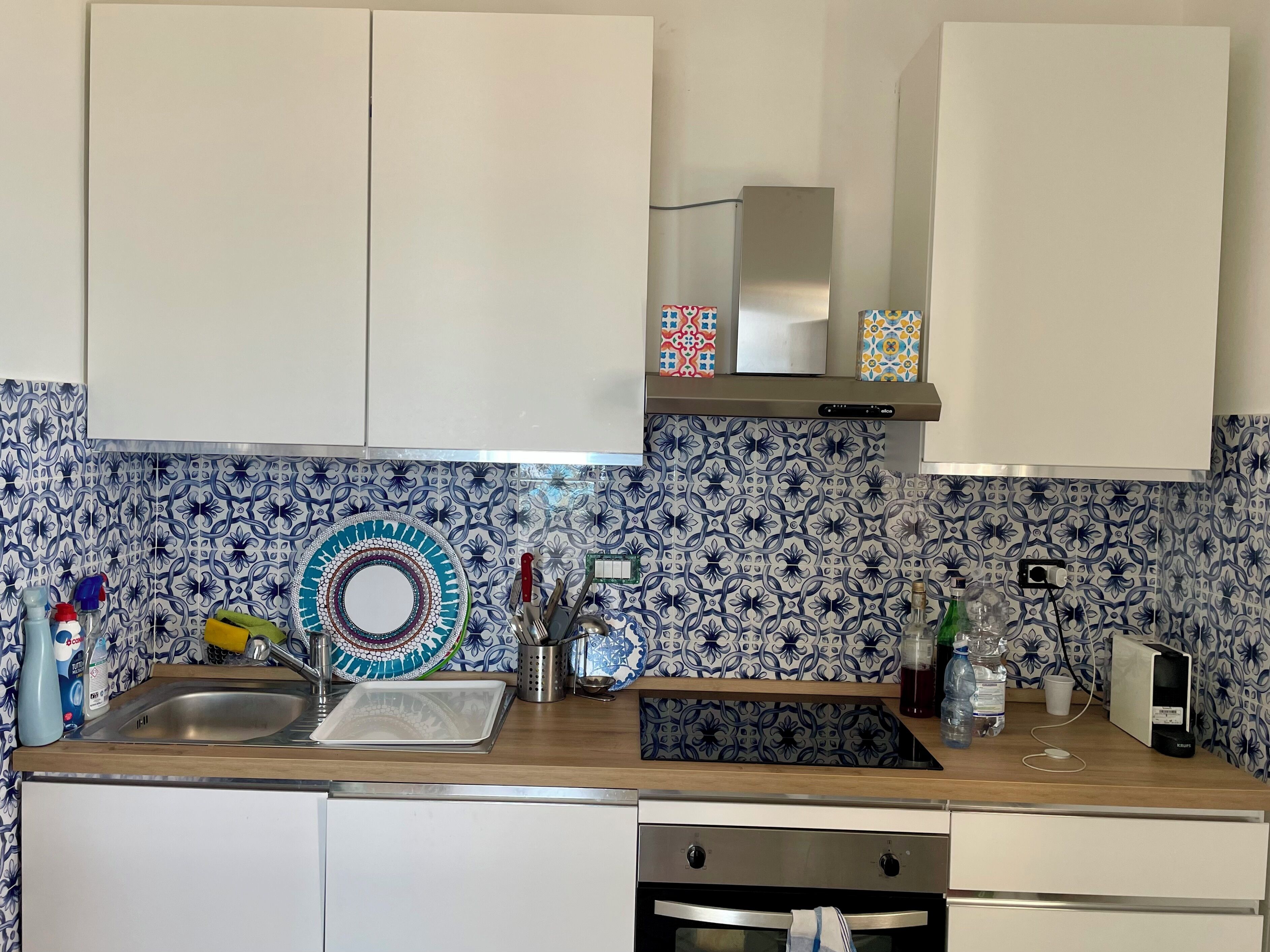 Una cocina con un lavamanos, estufa y armarios.
