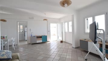 Un espacio habitable amplio con cocina, mesa de comedor y televisor.