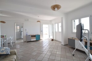 Un espacio habitable amplio con cocina, mesa de comedor y televisor.