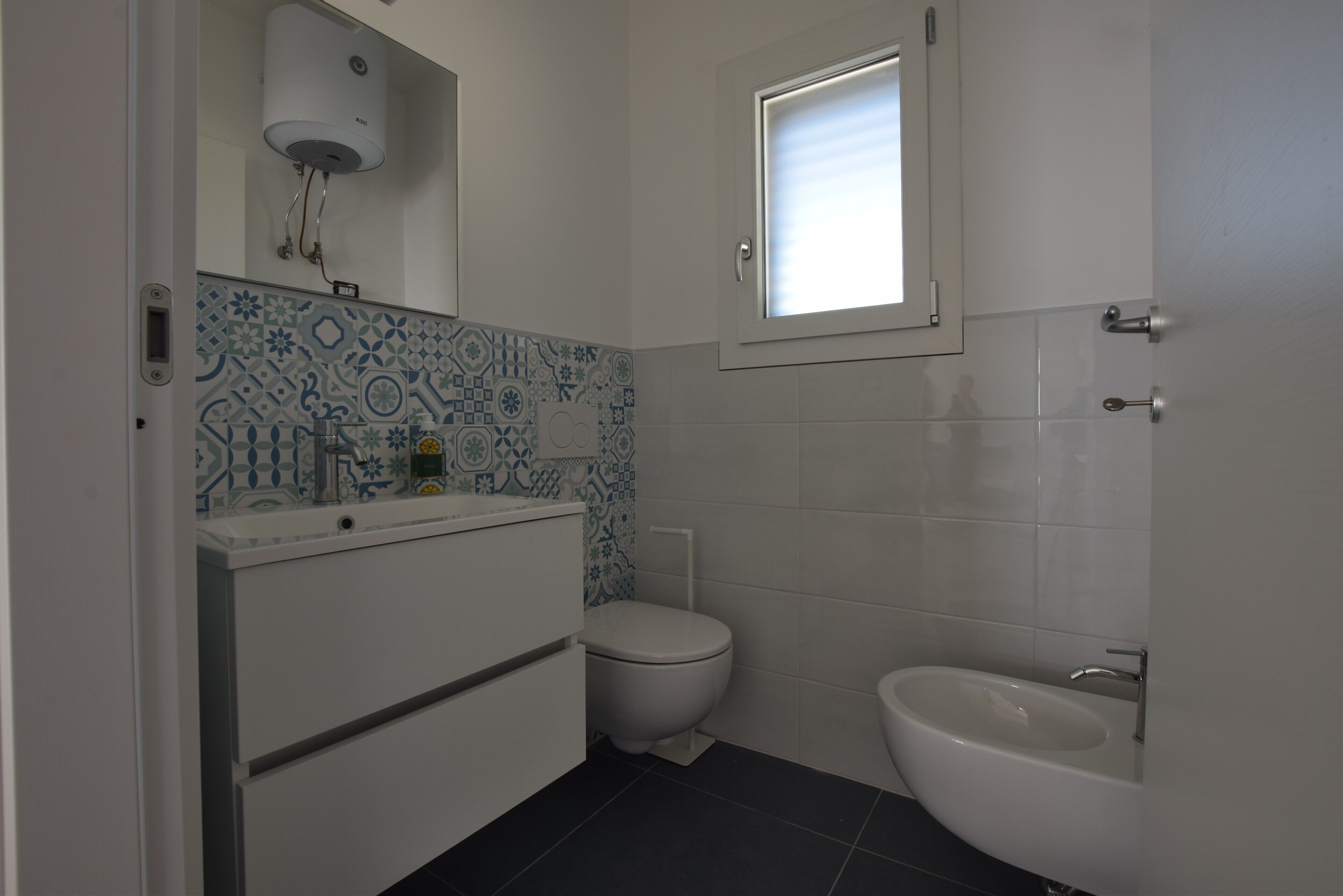 Une salle de bain équipée de toilettes, d’un bidet et d’un lavabo.