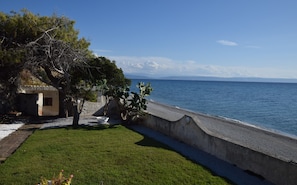 A coastal property with a paved walkway, a small building, and a view of the sea. - Villa Paola Caposuvero (Gizzeria Lido)
