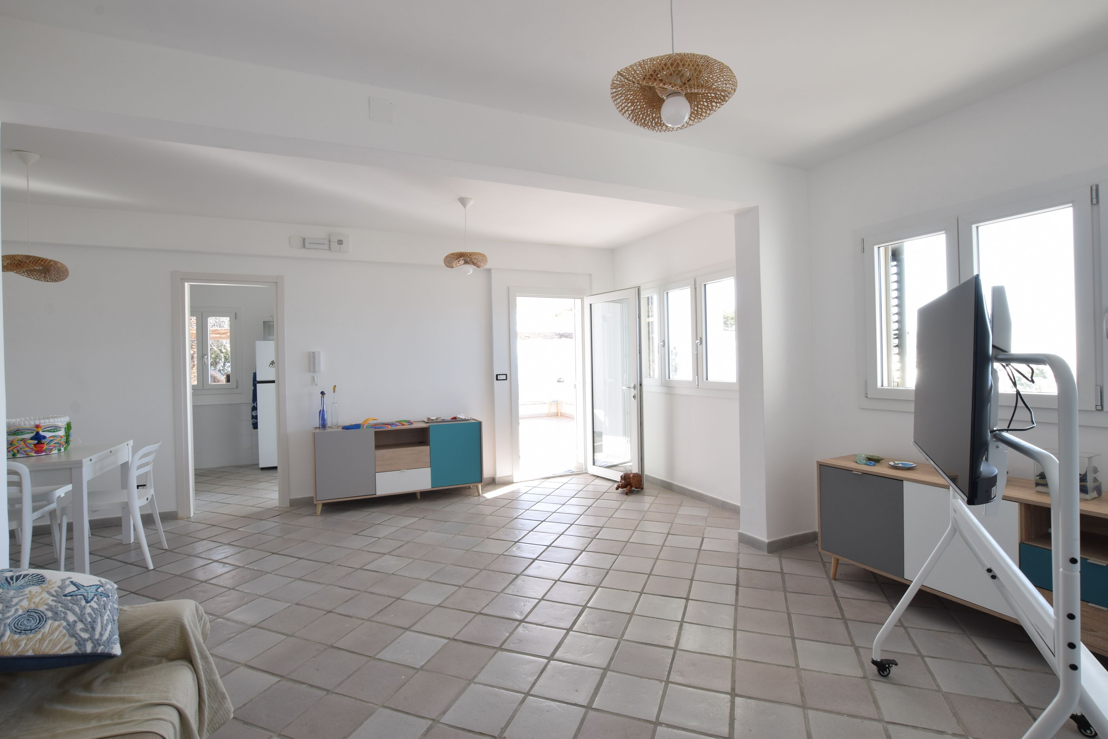 Un espacio habitable amplio con cocina, mesa de comedor y televisor.