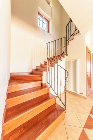 A wooden staircase with a metal railing leading to a landing. - Villa Pamela (Cassano Irpino)