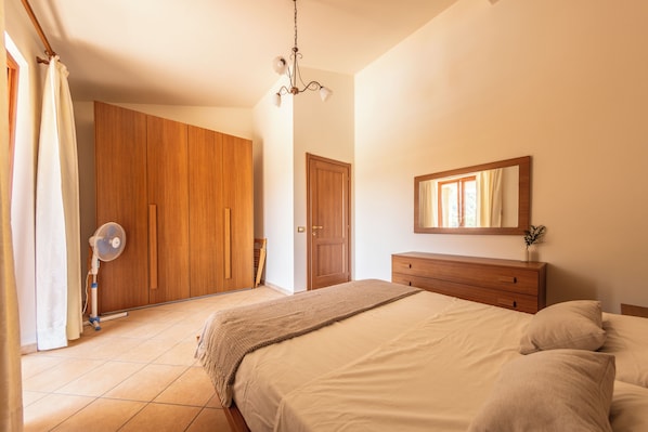 Une chambre à coucher avec un lit, une commode, un miroir et une armoire.