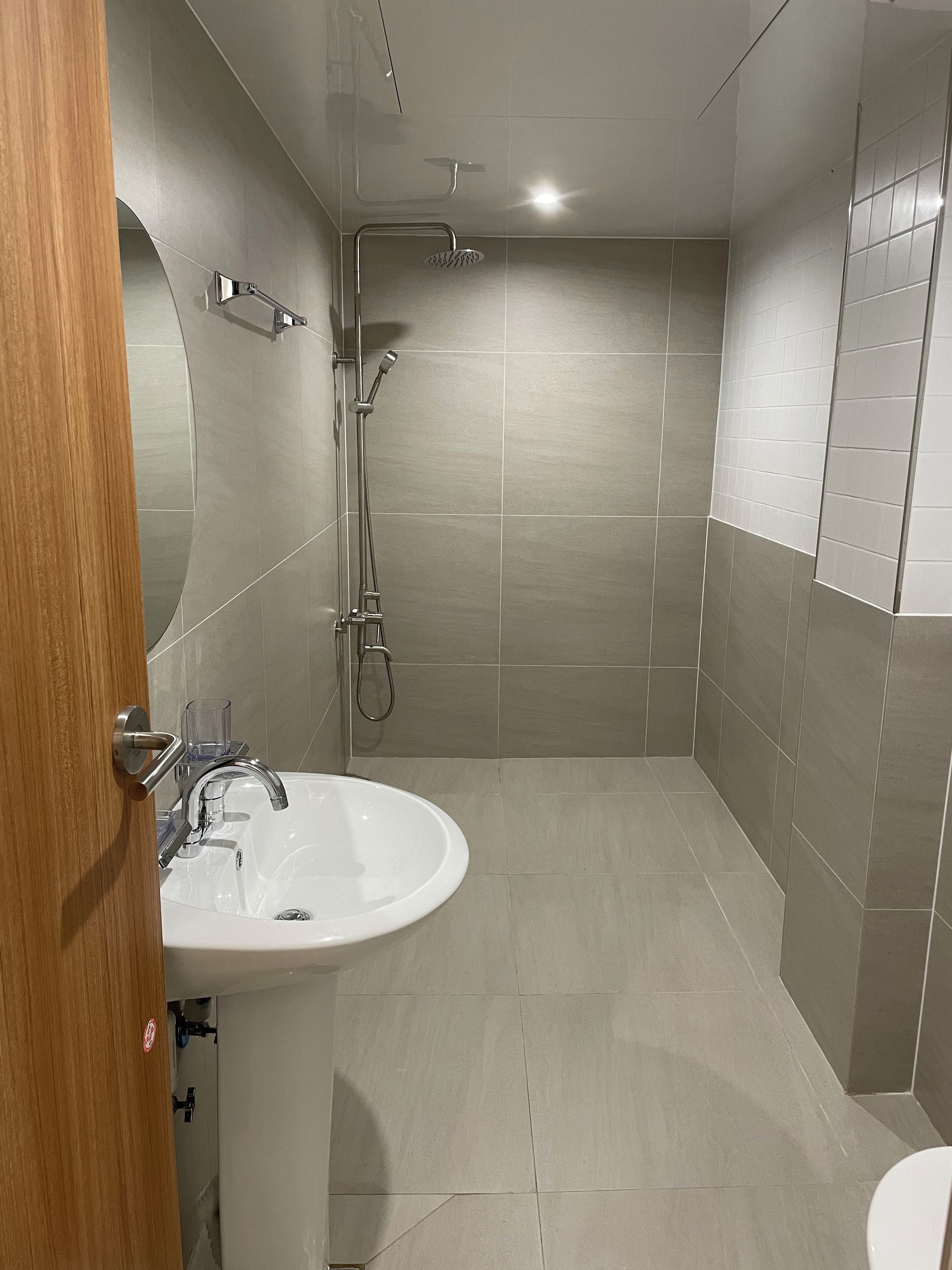 A modern bathroom with a sink, shower, and toilet.