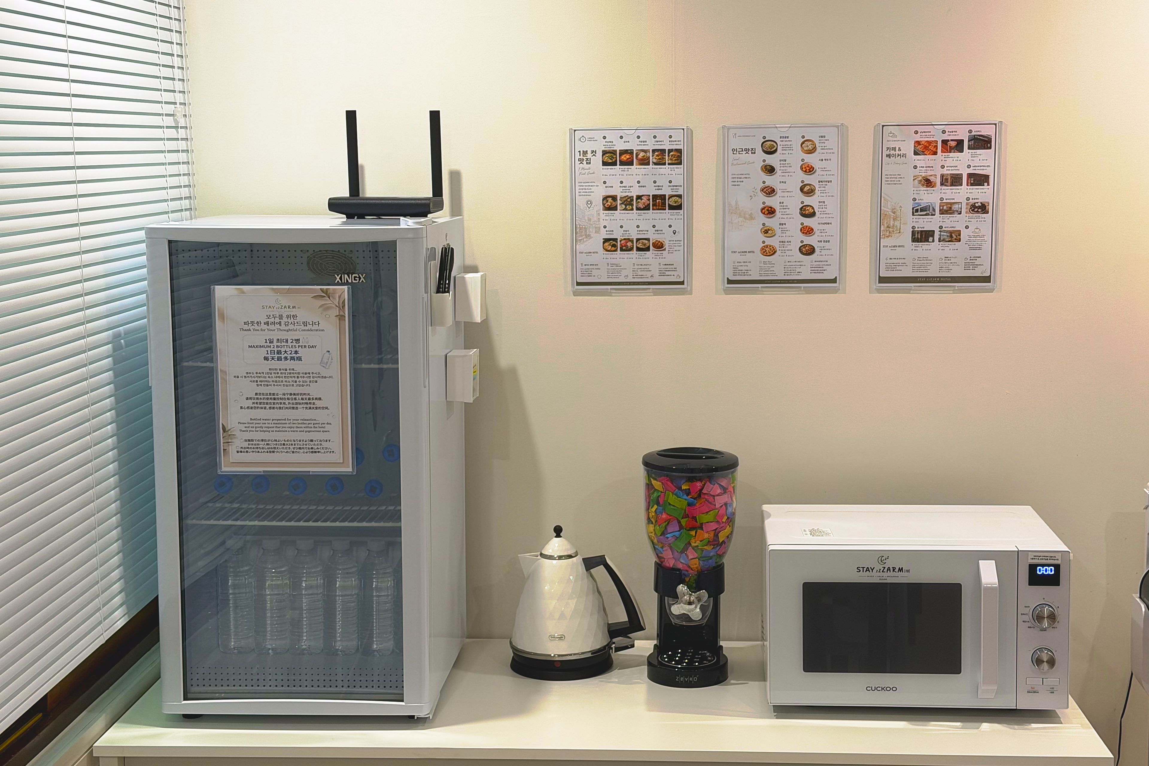 A kitchenette with a refrigerator, microwave, and coffee maker.