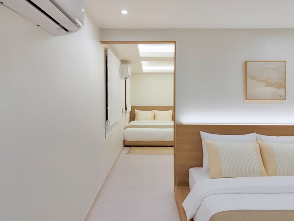 Quarto de hotel com cama, mesa de cabeceira, ar-condicionado fixado na parede e um quadro emoldurado.