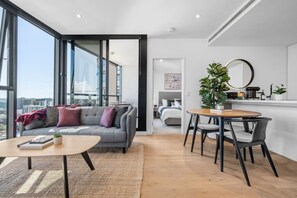 Ein modernes Wohnzimmer mit einer Couch, einem Couchtisch und einem Essbereich mit Stühlen.