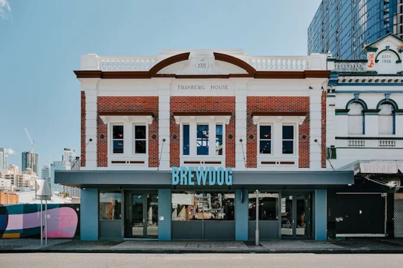Un edificio con un letrero que dice 'BREWDOG' y 'TRANBERG HOUSE' sobre la entrada.
