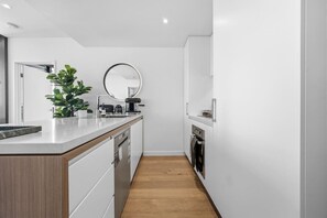 Eine moderne Küche mit einer Holz Arbeitsplatte, einer Kaffeemaschine und einem eingebauten Backofen.
