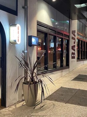 A building with a sign that reads 'BAJA' and a potted plant in the foreground. - The Skyline Residence on the 23rd Floor (Fortitude Valley)