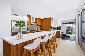 A modern kitchen with a central island, wooden cabinets, and a white countertop.