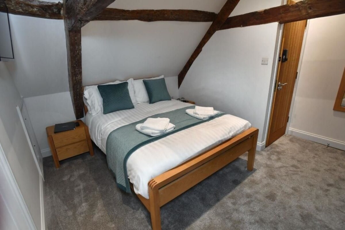 Un dormitorio con una cama de madera, una mesita de noche y una puerta.