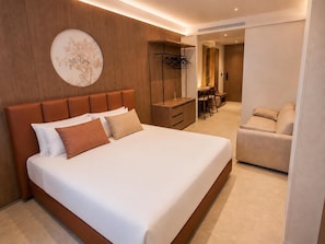 Une chambre d’hôtel moderne dotée d’un grand lit, d’un bureau et d’un coin salon.
