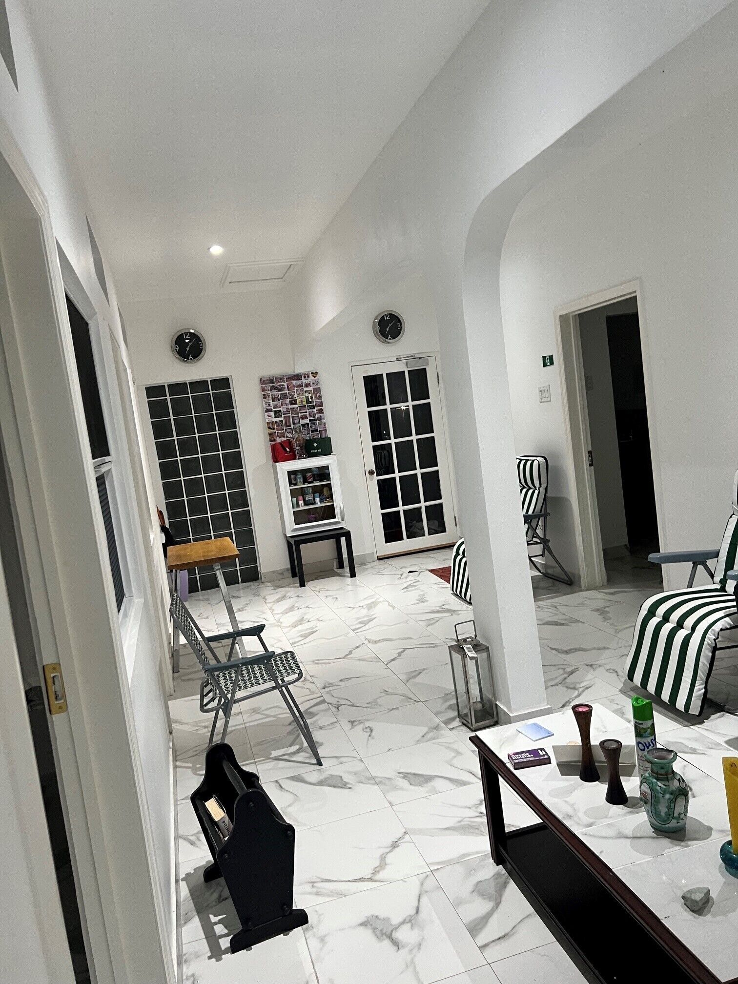 Un vaste espace de vie doté d’un sol carrelé, d’une table à manger et d’un coin salon comprenant une chaise et un canapé.