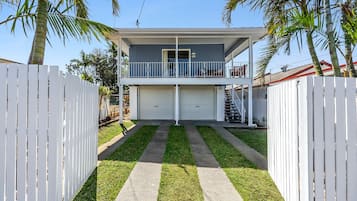 A two-story house with a balcony, a garage, and a well-maintained lawn.