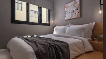 A modern bedroom with a large window, a bed with white linens, a gray throw blanket, a wooden bedside table with a plant, and a wall-mounted abstract painting.