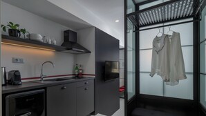 A modern kitchen with a built-in dishwasher, a coffee machine, and a wine bottle on the counter. - Binome Suites (Thessaloniki)