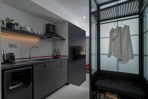 A modern kitchen with a built-in dishwasher, a coffee machine, and a wine bottle on the counter. - Binome Suites (Thessaloniki)