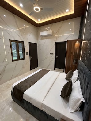 Un dormitorio moderno con una cama grande, un ventilador de techo y una ventana.