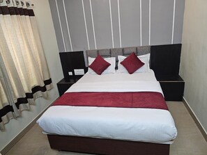 Una camera d'albergo standard con un letto, comodini e una tenda.