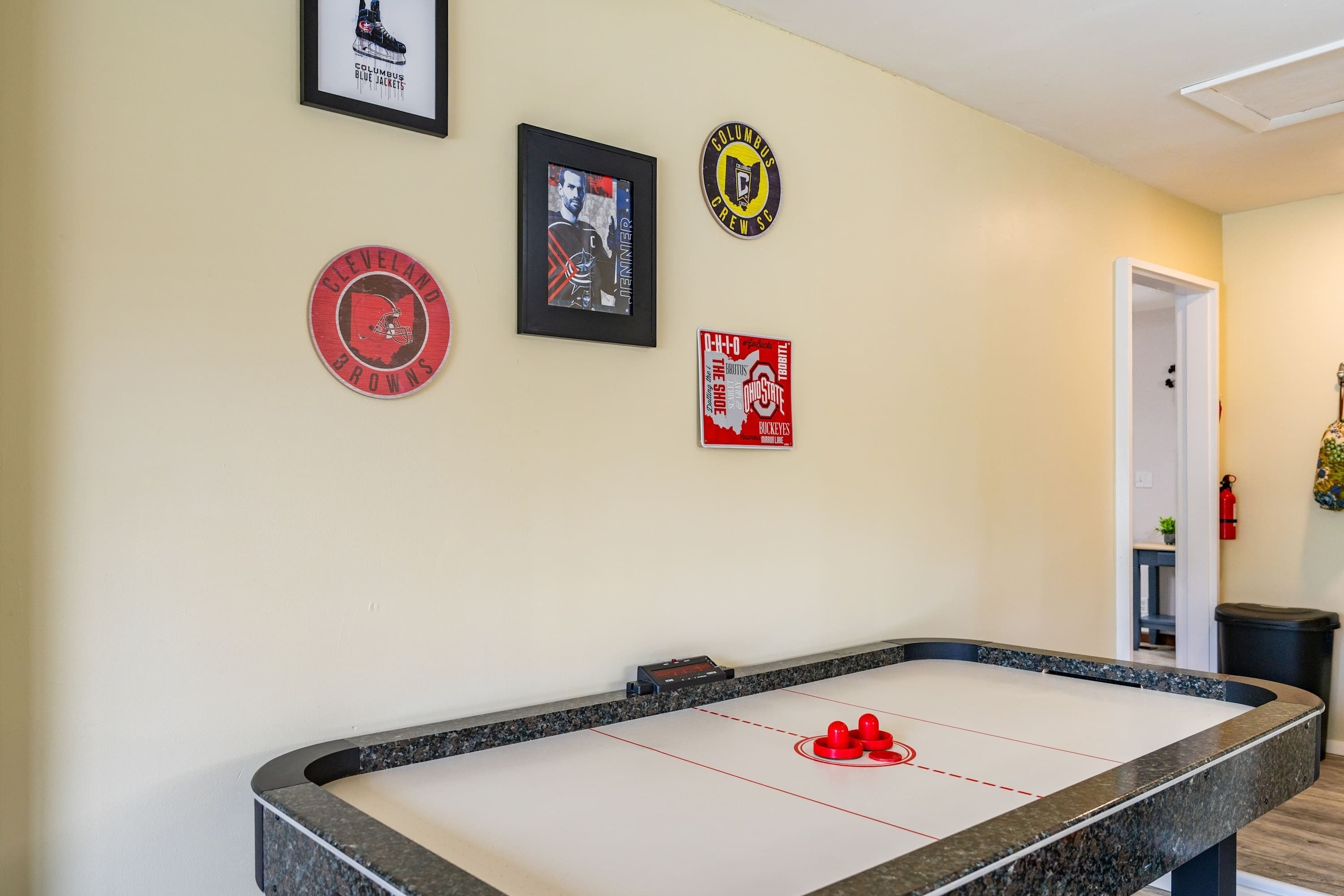 Une table de billard avec trois objets de collection sur le thème du sport, encadrés et accrochés au mur.