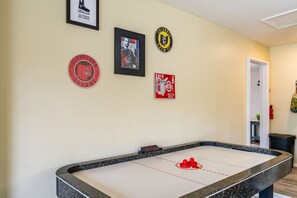 Une table de billard avec trois objets de collection sur le thème du sport, encadrés et accrochés au mur.