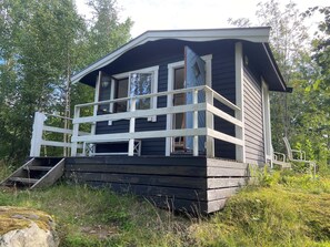 A cabin with a wooden deck, a staircase, and a porch. - 4 Star Holiday Home in Malmkoping (Malmkoping)
