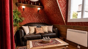 Una habitación acogedora con un sofá de cuero, una mesa de centro de madera y una alfombra estampada.