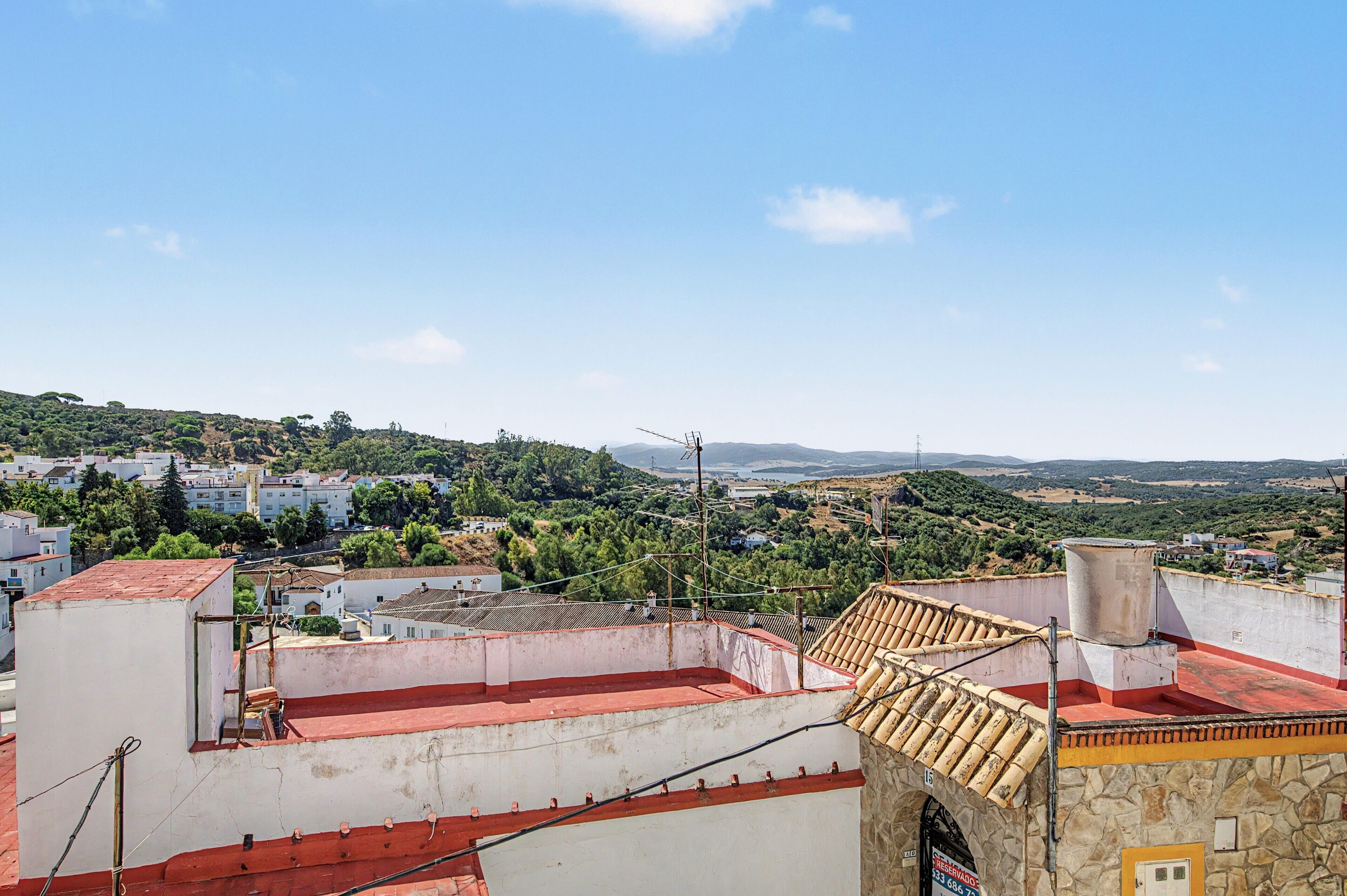 Zona residencial con vistas a un paisaje montañoso, con casas y vegetación.