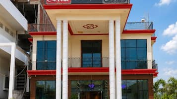 A hotel with a Coca-Cola sign, a flag, and a modern entrance.