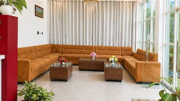 A modern living room with a sectional sofa, two coffee tables, and a red cabinet.