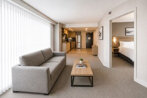 Ein modernes Hotelzimmer mit einer Couch, einem Holztisch und einem Bett.