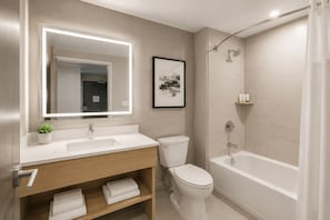 Ein modernes Badezimmer mit Waschtisch, Toilette und Badewanne.