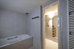 Un bagno moderno con una vasca, uno specchio e uno scaffale.