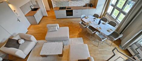 Interior moderno com cozinha, sala de jantar e área de estar.