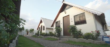 A residential building with a sloped roof, a front door, and a window with decorative bars.