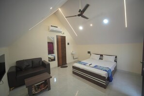 Un dormitorio con cama, sofá, ventilador de techo y unidad de aire acondicionado.